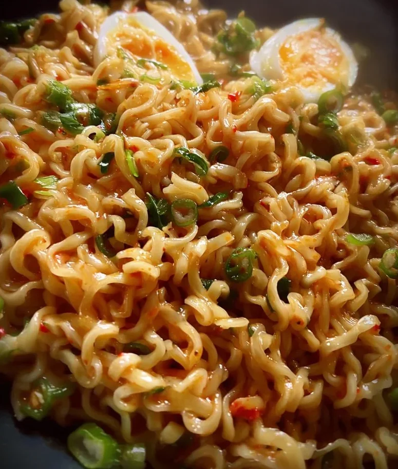Creamy Buldak Noodles with spicy sauce and garnish in a bowl
