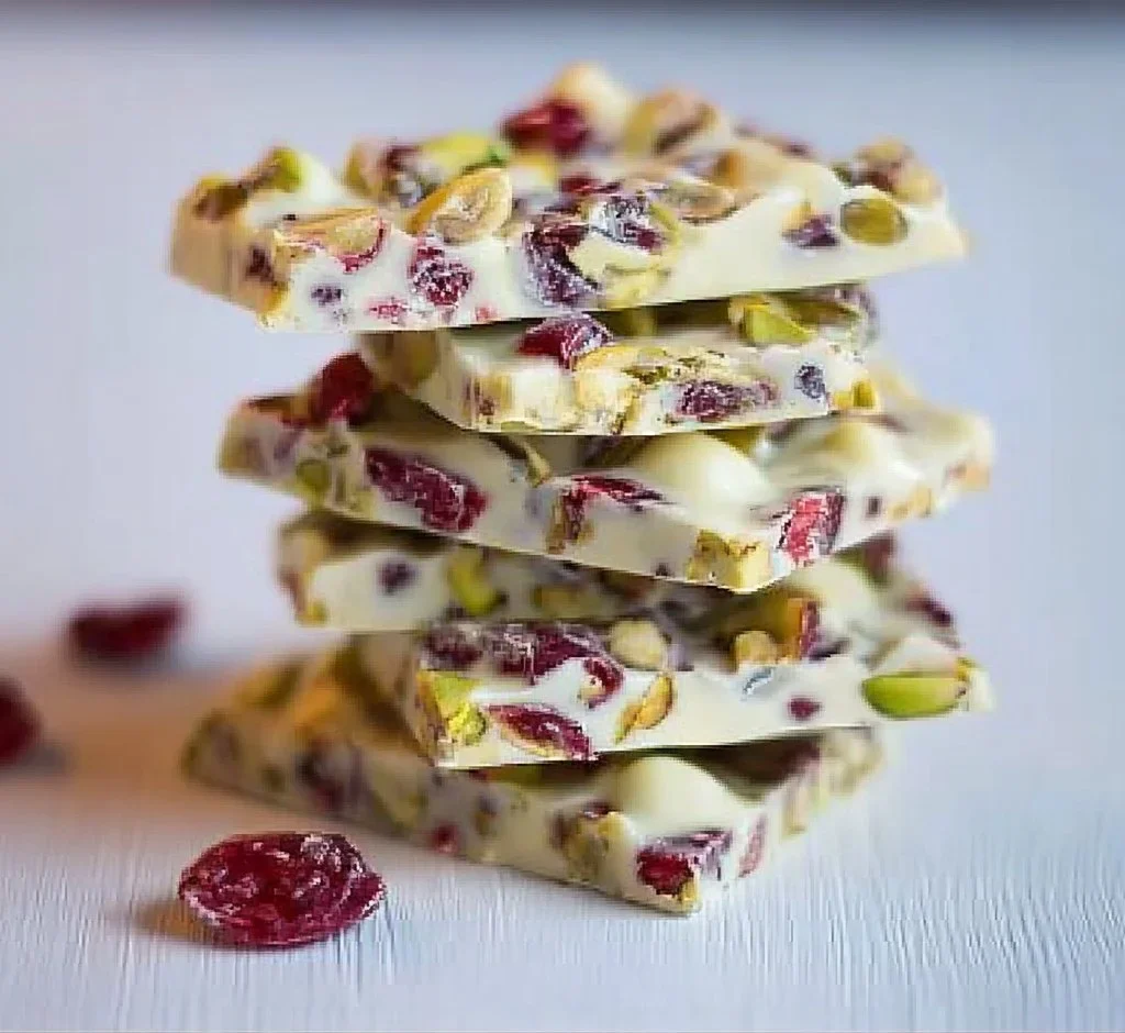 Cranberry pistachio white chocolate bark on a wooden board