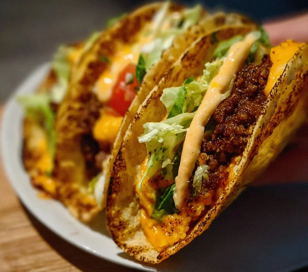 Delicious easy smash burger tacos with toppings on a plate.