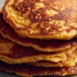 Fluffy sweet potato pancakes served on a plate with maple syrup